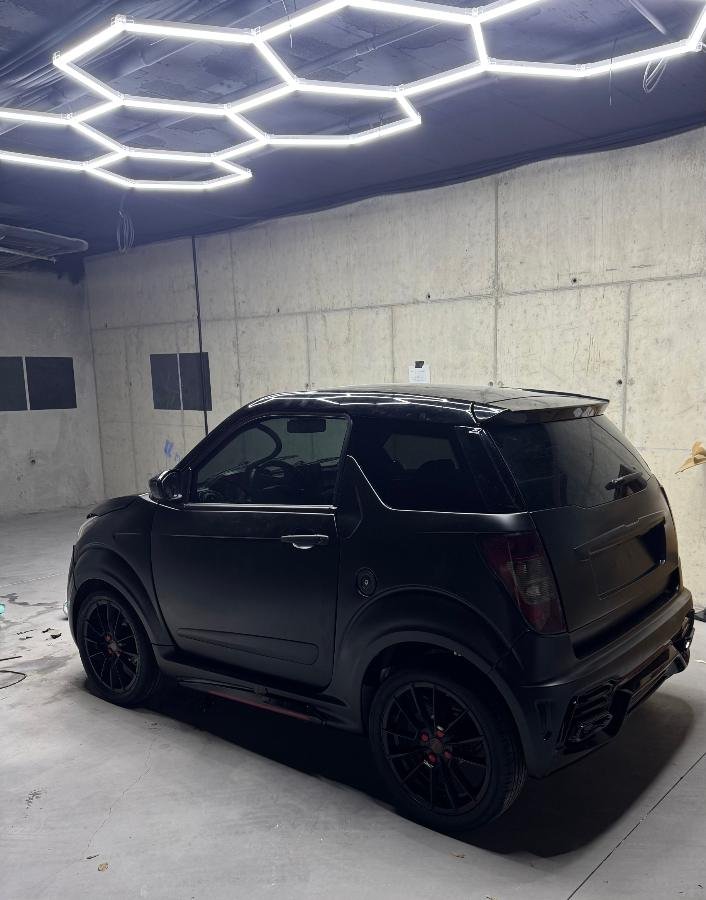Microcoche Ligier con Car Wrap negro mate, tres cuartos trasero en el estudio